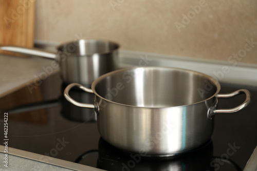 Metal pots on electric kitchen stove, selective focus