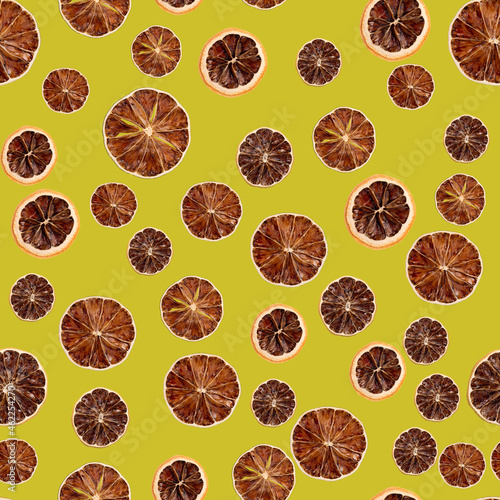 Dry lime slices on seamless colored background