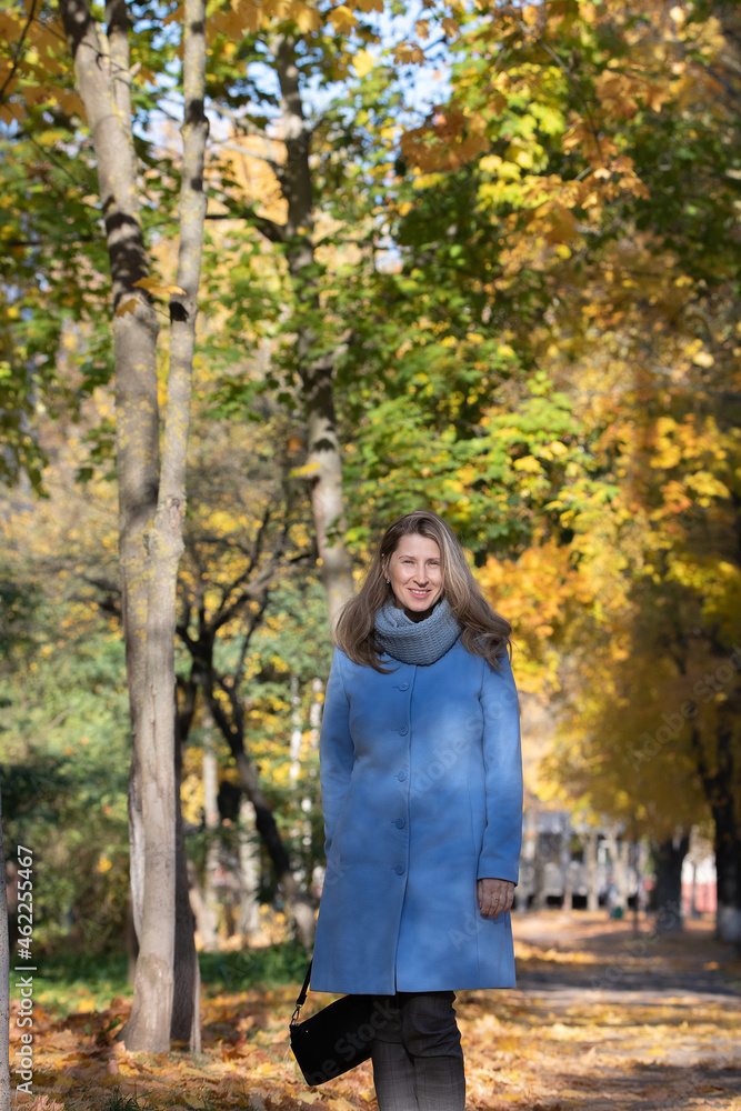 Portrait of a beautiful young blonde girl in a blue coat in an autumn park, close-up. Portrait of a beautiful young blonde girl in a blue coat in an autumn park, close-up.