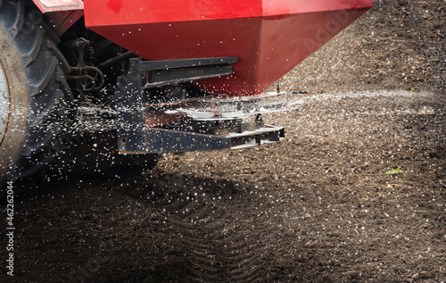 Fotografi Tractor spreading artificial fertilizers in field