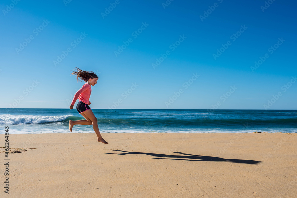 cute young girl running and jumping on sunny beach cute young girl running and jumping on sunny beach