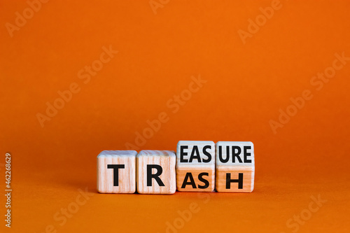 Trash to treasure symbol. Businessman turned cubes and changed the word trash to treasure. Beautiful orange table, orange background. Business, trash to treasure concept. Copy space.