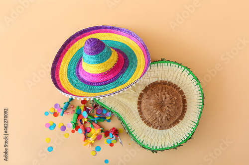 Mexican pinata in shape of avocado  sombrero hat and confetti on color background