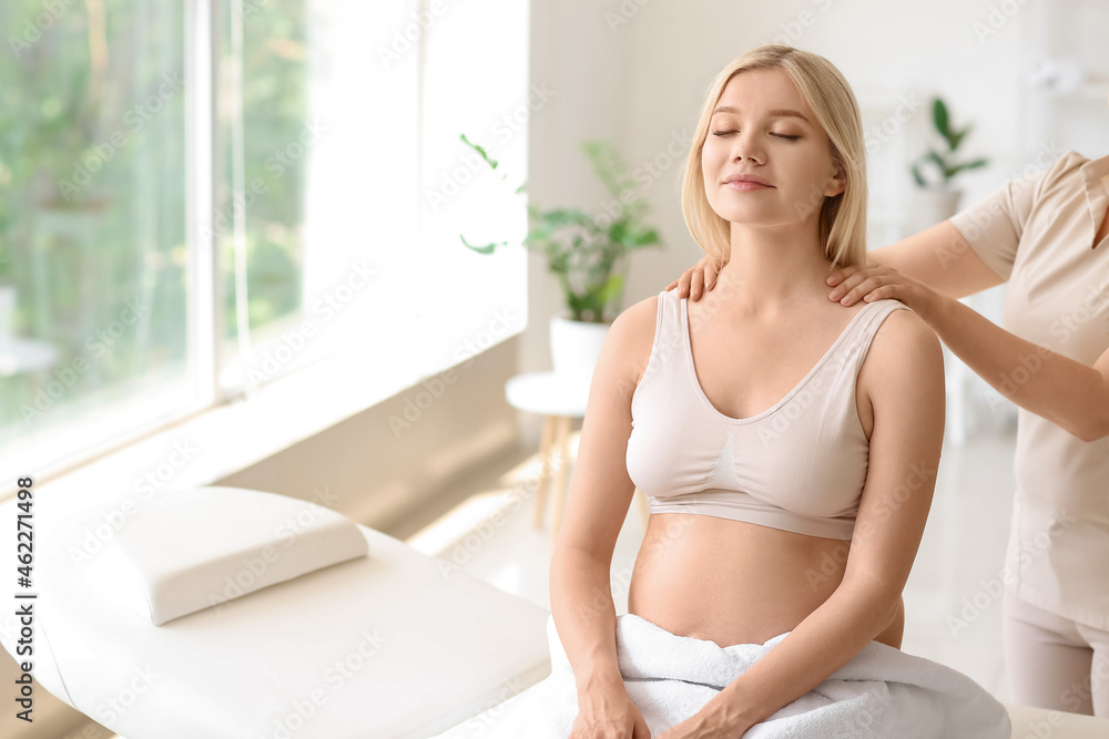 Young pregnant woman having massage in spa salon Young pregnant woman having massage in spa salon