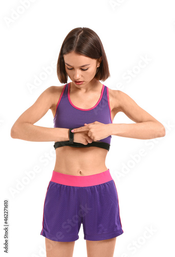 Sporty female runner checking pulse on white background © Pixel-Shot