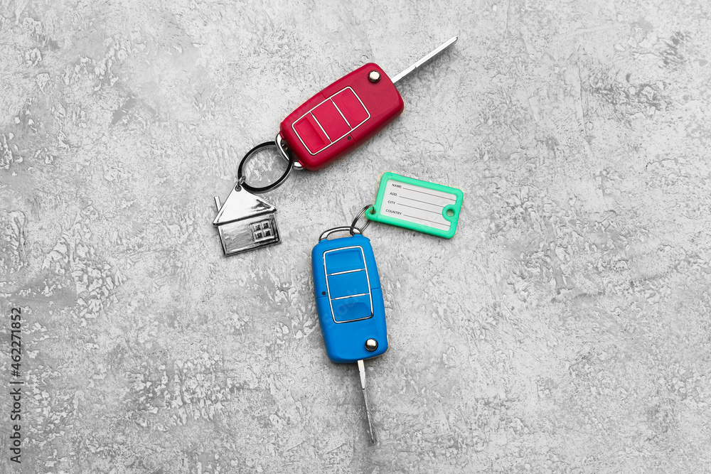 Car keys with plastic tag and keychain on grunge background