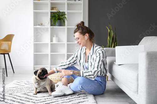 Young woman with cute pug d...