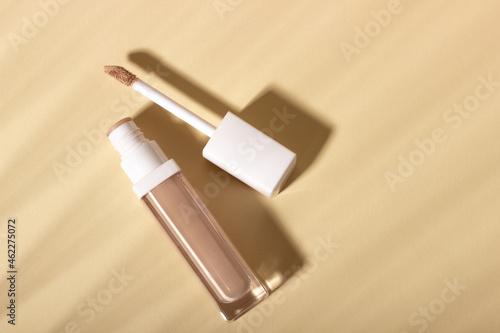 Concealer cream on a background with shadows. Face corrector on beige background with copy space. Blank mockup for product