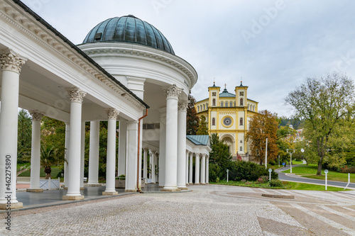 Colonnade (Kolonada) of Karolina and Rudolf springs (Karolinin - Rudolfuv pramen) and catholic church in the center of spa town Marianske Lazne (Marienbad) - Czech Republic photo