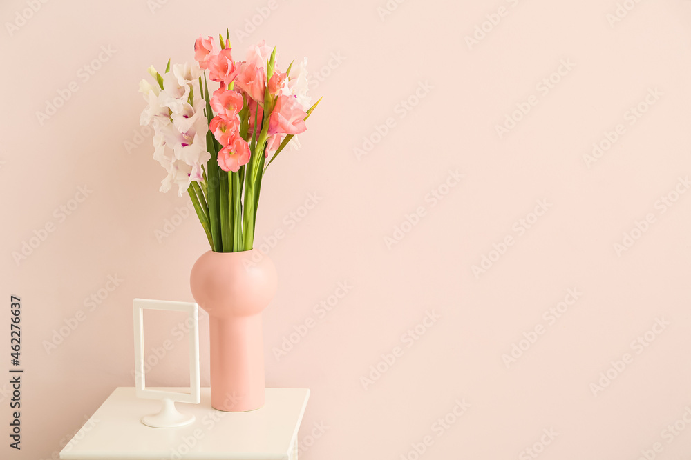 Vase with gladiolus flowers on table in room Vase with gladiolus flowers on table in room
