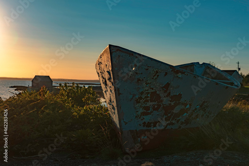 Abandoned fishing boat with peeling paint at Blue Rocks, Nova Scotia during sunset photo