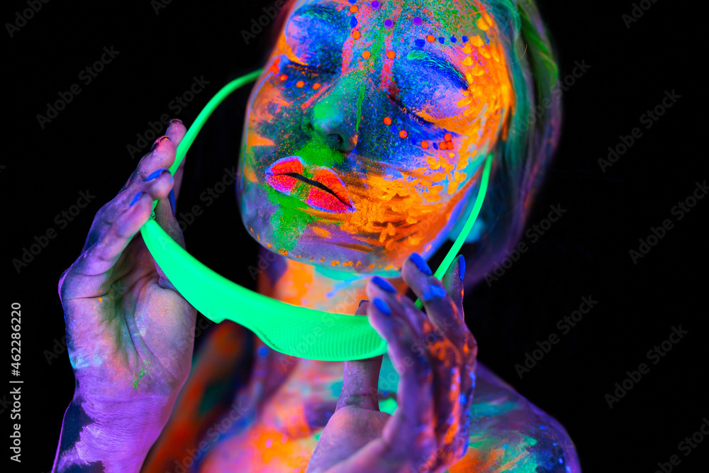 Beautiful model woman wearing glasses with colorful bright fluorescent makeup in neon light, nightclub disco. - obrazy, fototapety, plakaty 