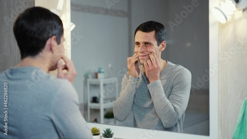 Man making with fingers a false smile