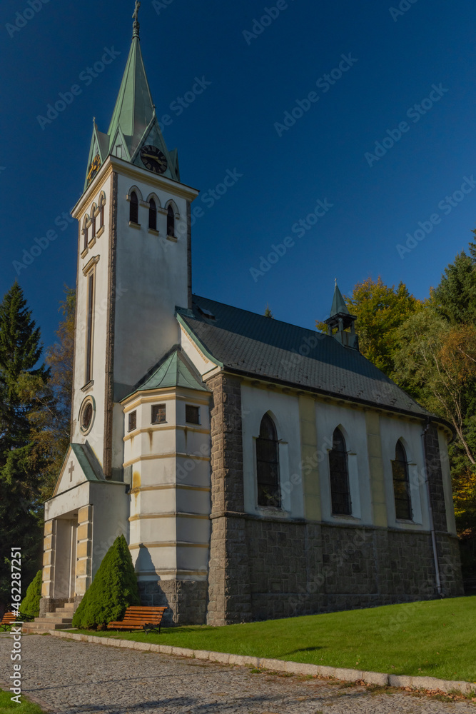 Fototapeta premium Church in Bedrichov village in autumn sunny evening with sunset light