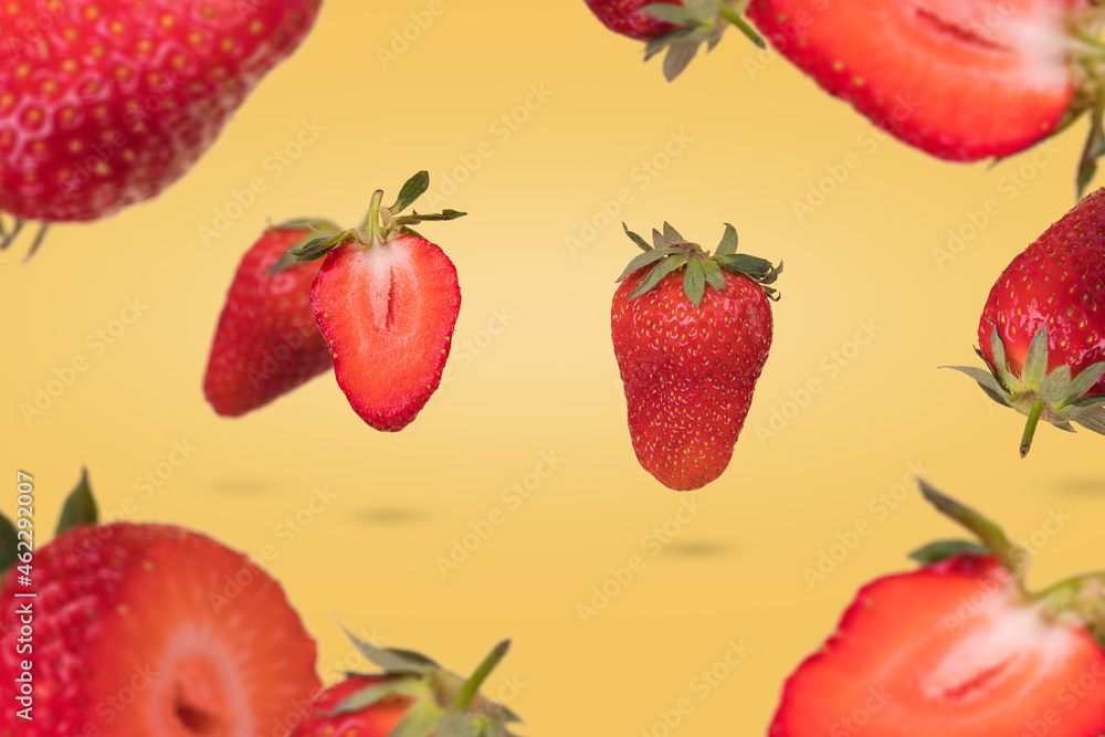 Creative composition with floating levitating ripe strawberries on a yellow background. Vitamins, fresh healthy food concept. Creative composition with floating levitating ripe strawberries on a yellow background. Vitamins, fresh healthy food concept.