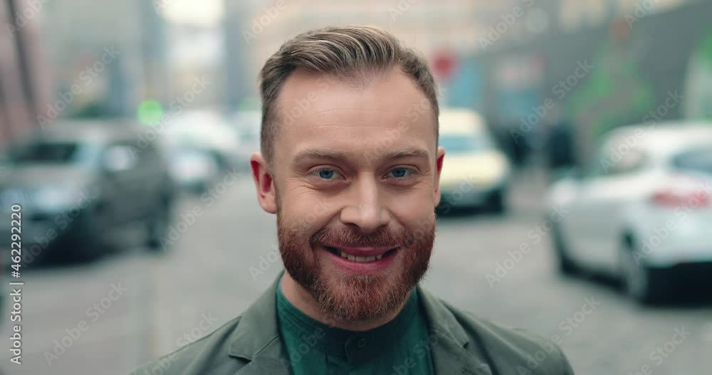 Close up portrait of successful caucasian businessman standing on street in stylish jacket and looking at camera smiling. Close up portrait of successful caucasian businessman standing on street in stylish jacket and looking at camera smiling.