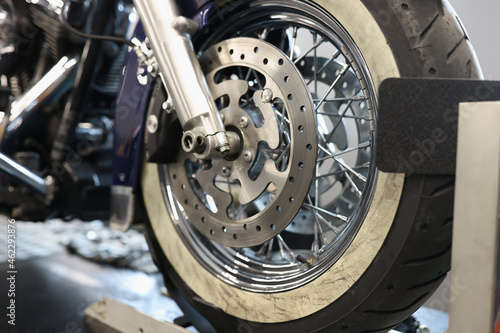 Front motorcycle wheel with shiny brake disc closeup