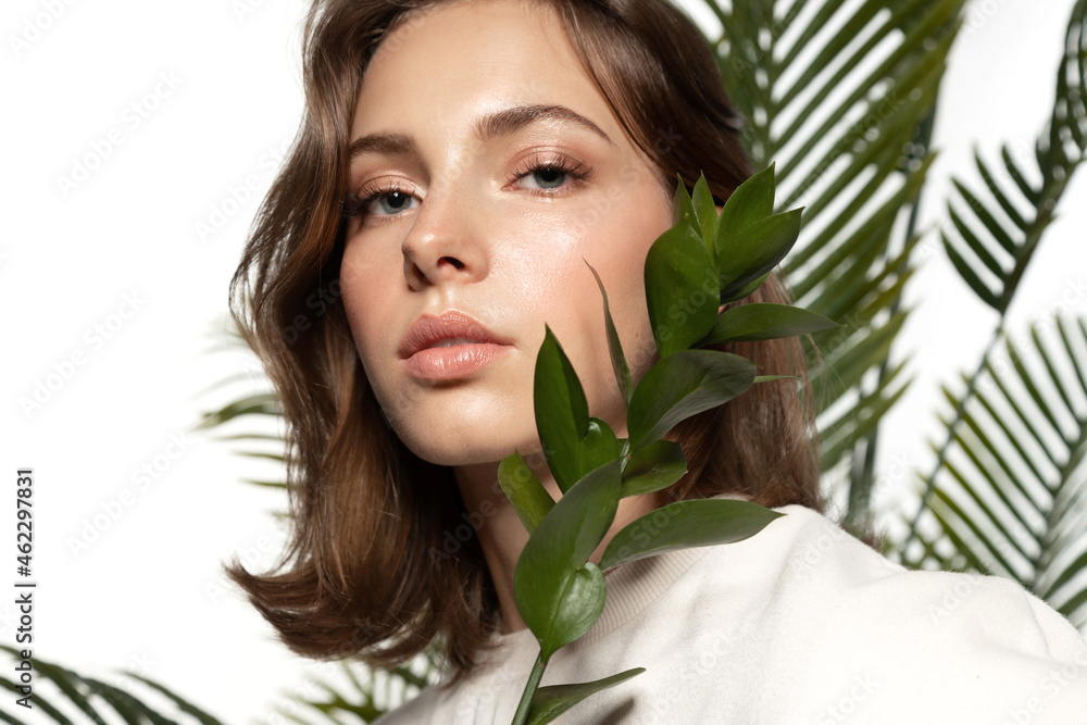 Beautiful girl with perfect skin and natural make-up holding tropical flowers Beautiful girl with perfect skin and natural make-up holding tropical flowers