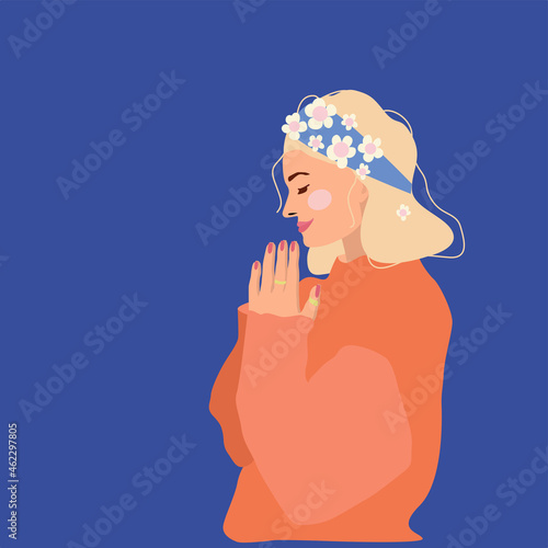 The woman holds her hands in front of her. The concept of femininity, harmony, self-acceptance and gratitude. Portrait of a face in profile on a dark blue background with a copy of the space.