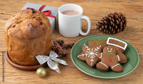Traditional christmas gingerbread cookies and panettone over a wooden table