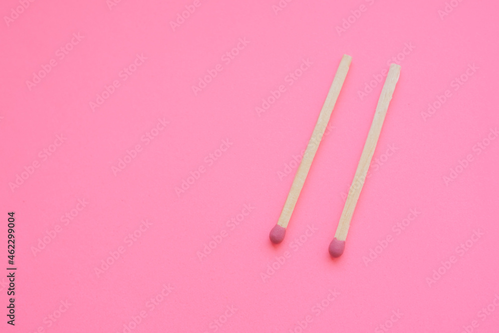 two matches on a pink paper table two matches on a pink paper table