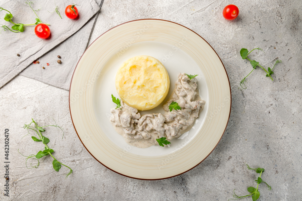 Stroganoff from beef with mashed potatoes on plate top view on grey table Stroganoff from beef with mashed potatoes on plate top view on grey table
