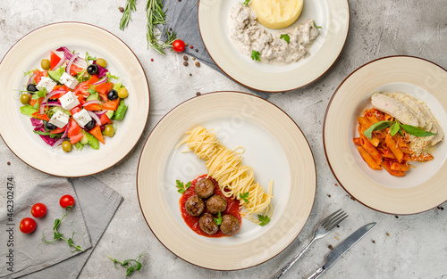 Fototapeta Naklejka Na Ścianę i Meble -  Spaghetti with meatballs, greek salad, stroganoff with beef and mashed potatoes, penne with chicken top view