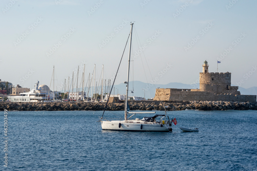 White boat sailing close to the coast blue aegean sea in Greece White boat sailing close to the coast blue aegean sea in Greece
