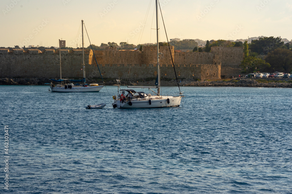 White boat sailing close to the coast blue aegean sea in Greece