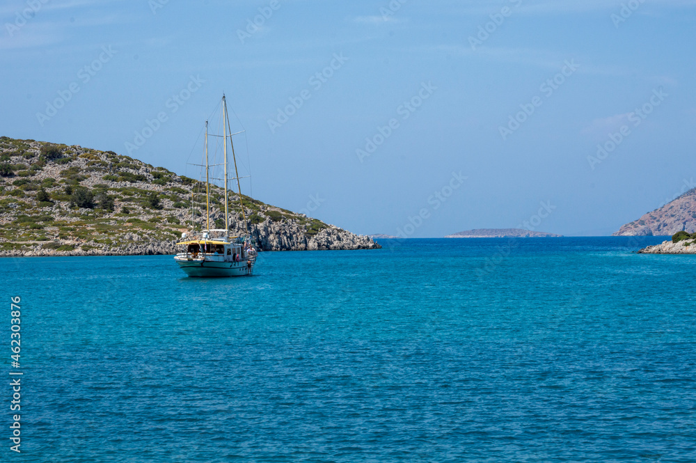 White boat sailing close to the coast blue aegean sea in Greece White boat sailing close to the coast blue aegean sea in Greece