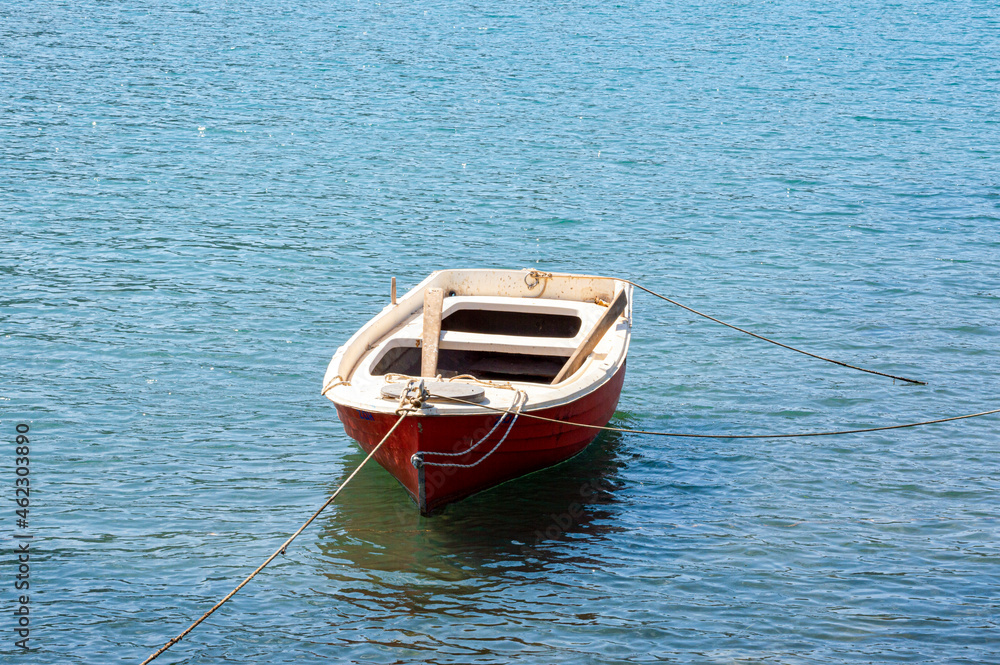 Naklejka premium Small red boat rustic wooden anchored in Greece