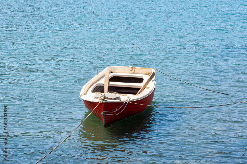 Small red boat rustic wooden anchored in Greece