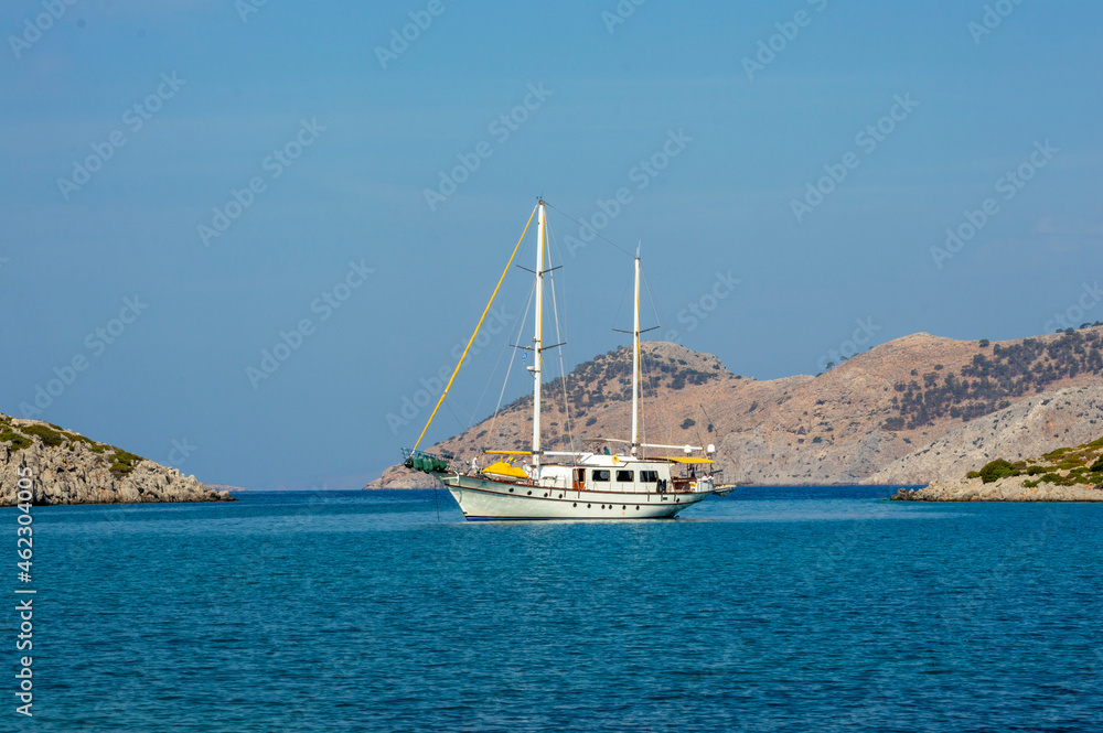 White boat sailing close to the coast blue aegean sea in Greece White boat sailing close to the coast blue aegean sea in Greece