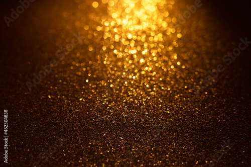 Background of gold and black glitter lights. De-focused abstract background. 