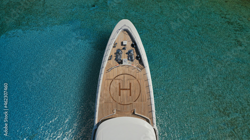 Aerial drone top down photo of luxury exotic yacht nose with wooden deck anchored in paradise turquoise bay