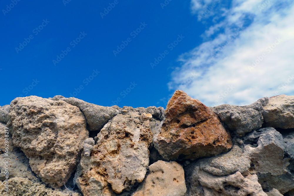 Rough stone wall with blue sky and white clouds in the background of Kenya Africa for copy space
