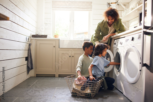 Foto Boys doing laundry with father watching