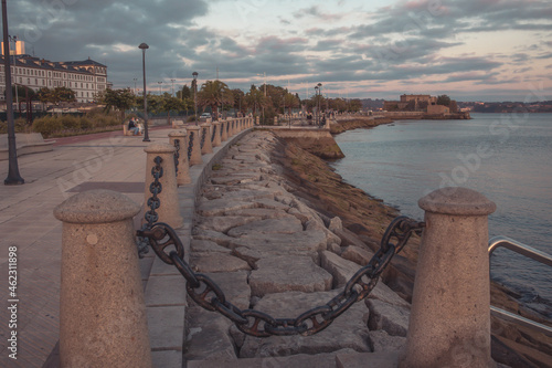 Embankment of the city of la coruña. The bud pillars of the fence on the embankment. Ocean, castle of san antonio
