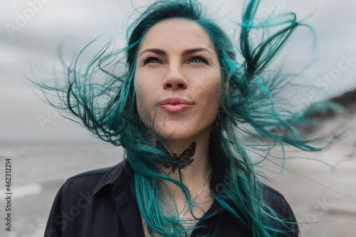 portrait of a beautiful woman with blue hair that flutters in the wind