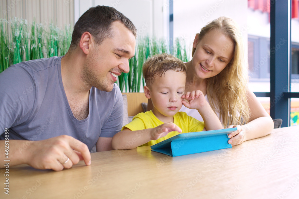 Happy family of three with tablet computer in cafe Happy family of three with tablet computer in cafe
