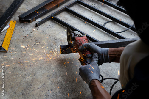 Close up, A man working with angle grinder. Iron gate repair