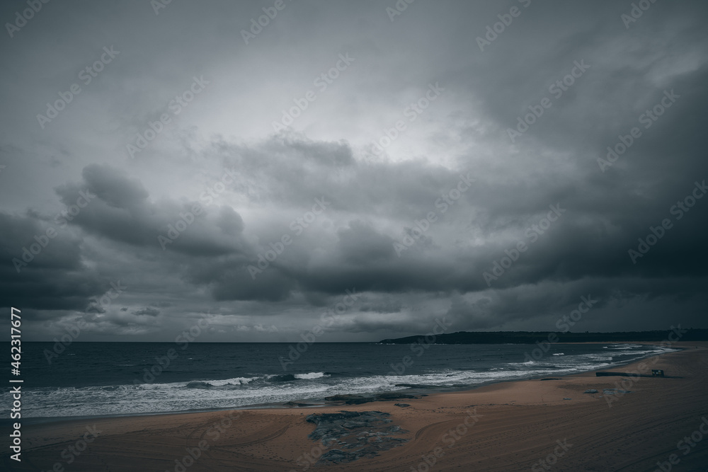 storm over the beach with surfers in the water storm over the beach with surfers in the water