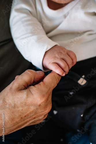 Close up of baby holding grandmother s finger