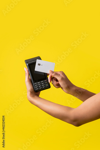 vertical de la mano de una mujer afroamericana con un sistema de cobro con tarjeta de debito o crédito 