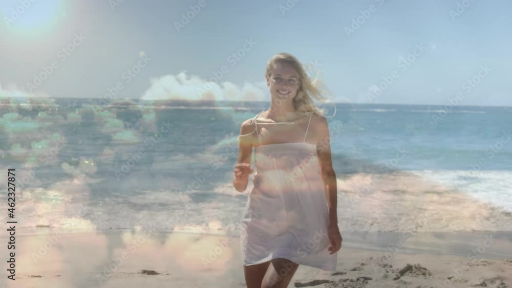Animation of clouds over smiling caucasian woman walking on beach Animation of clouds over smiling caucasian woman walking on beach