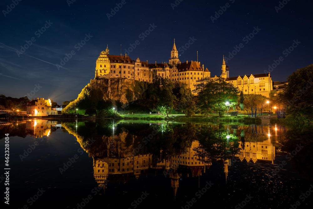 Hohenzollern Castle in Sigmaringen, Germany is reflected in the water of the Danube river at night
