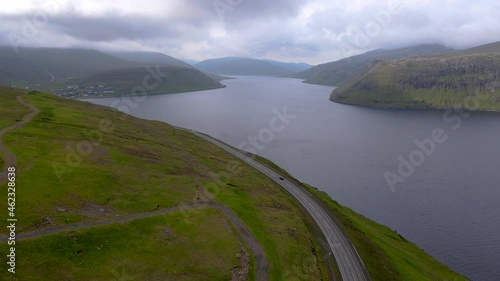 Beautiful cinematic aerial footage of the empty roads in the Fareo Islands with its amazing Mountains, in the coast line 