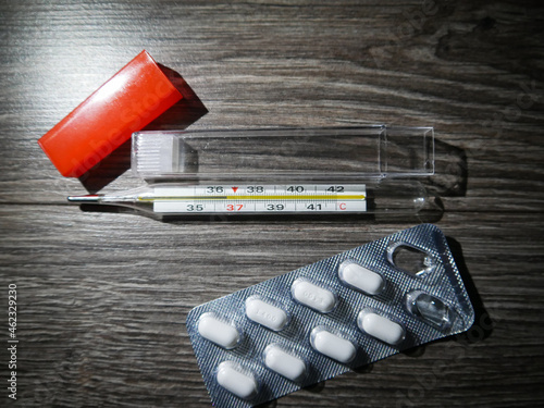 thermometer lying on a black wooden background, treatment, illness, temperature