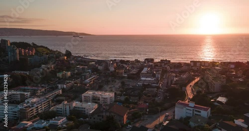 Aerial hyperlapse of the buildings in Renaca with the sun setting in the background photo