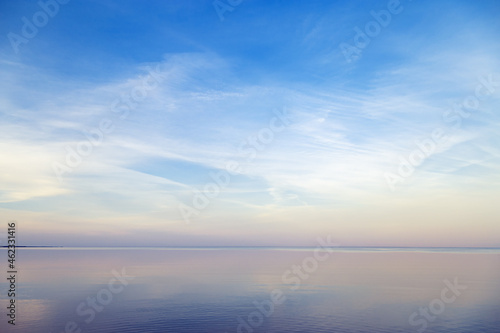 Sky background on sunset  colorful clouds. Nature abstract composition with reflections on sea water. Nature environment.